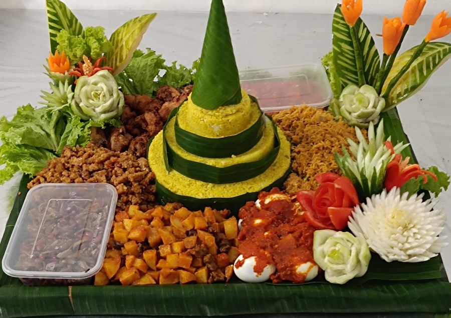 Hidangan tumpeng nasi kuning dengan aneka lauk dan hiasan sayur buatan Dapoer Suprihatin